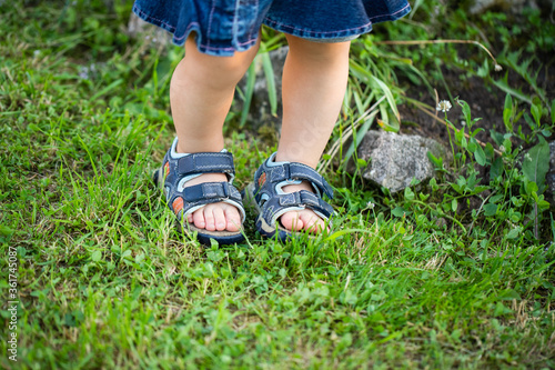 Baby Legs Of Girl Walking On Grass In Summer Close Up