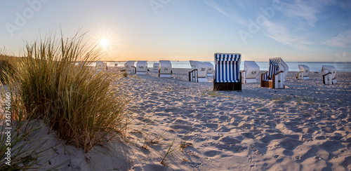 Canopied beach chairs at beach near Prerow (Darß Peninsula, Germany) in evening light photo