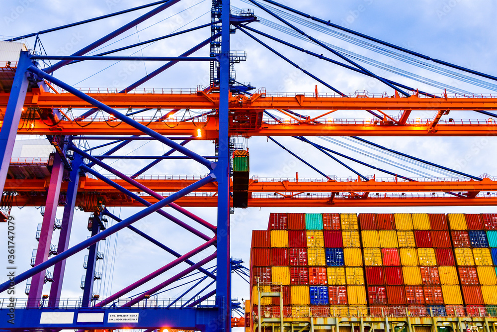 Quay crane pick up container from truck onto ship. Huge Panamax size ...
