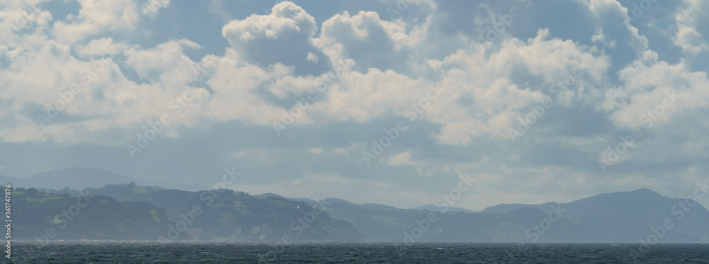 Beautiful cloudscape over the Atlantic ocean in hot summer day. Breathtaking seascape in Zumaia in Basque Autonomous Community / country in summer cloudy day. Biscay Bay. High resolution photography