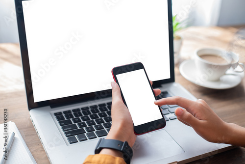 Woman holding blank screen mock up mobile phone and finger touching