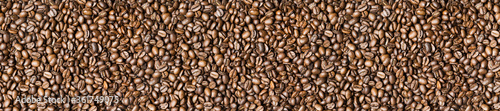 Roasted coffee beans background - full frame detail. Close up of a brown surface texture of aroma black caffeine drink ingredient for coffee beverage. Wide format banner
