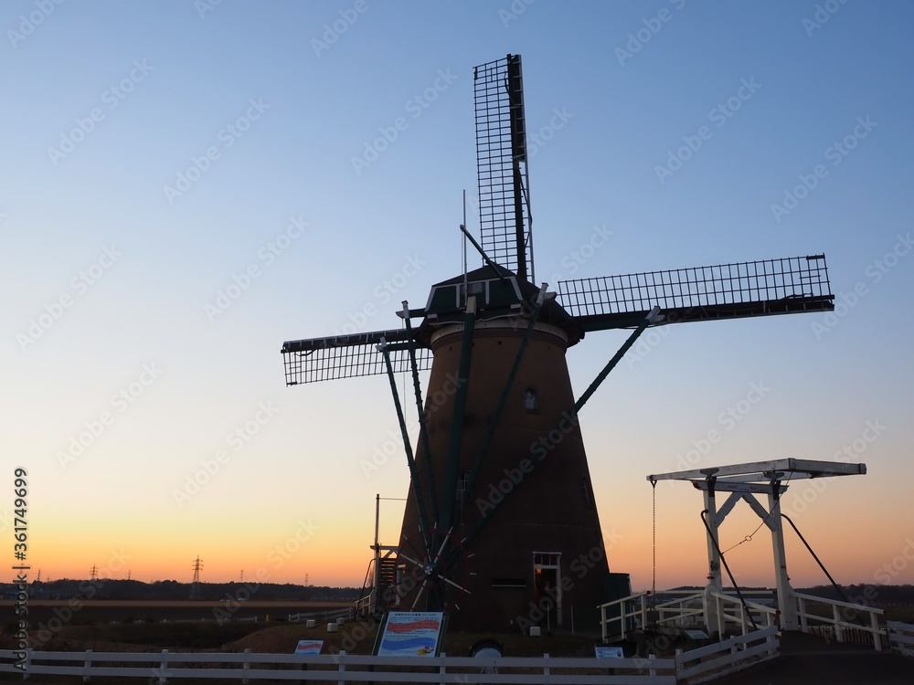 windmill stands in sunset background