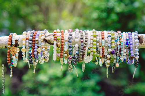 Stampa su tela Collection of crystals mineral stone beads yoga bracelets hanging on the branch