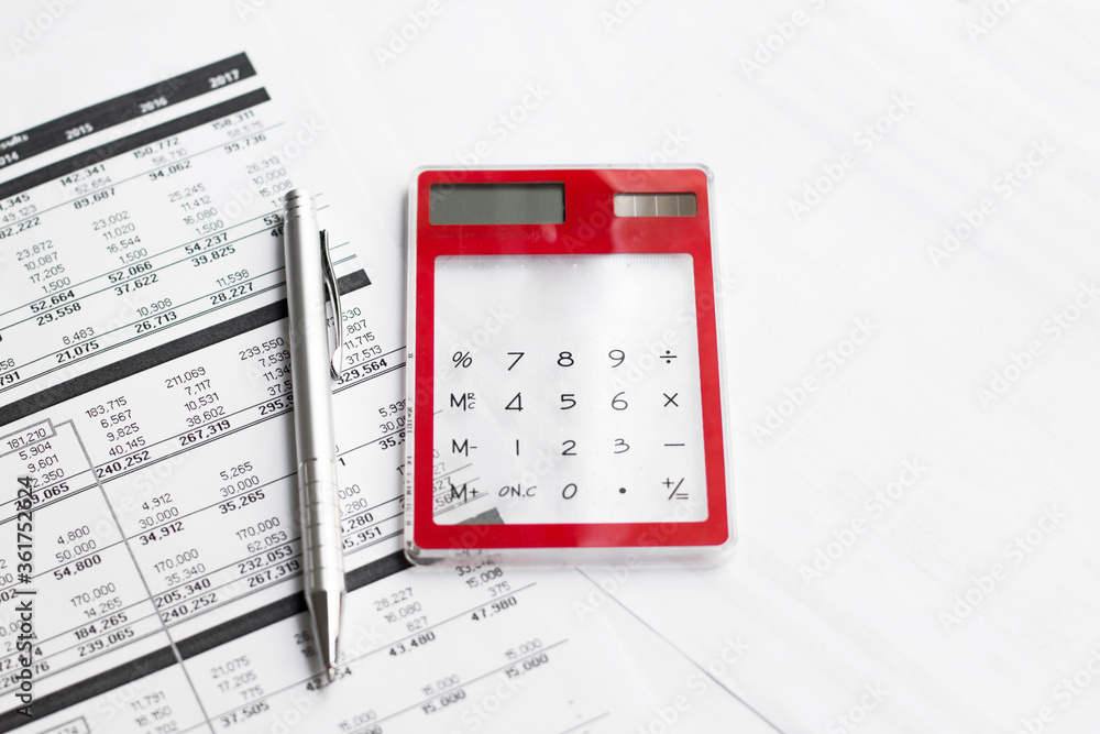 Calculator with pen on finance papers background Calculator with pen on finance papers background