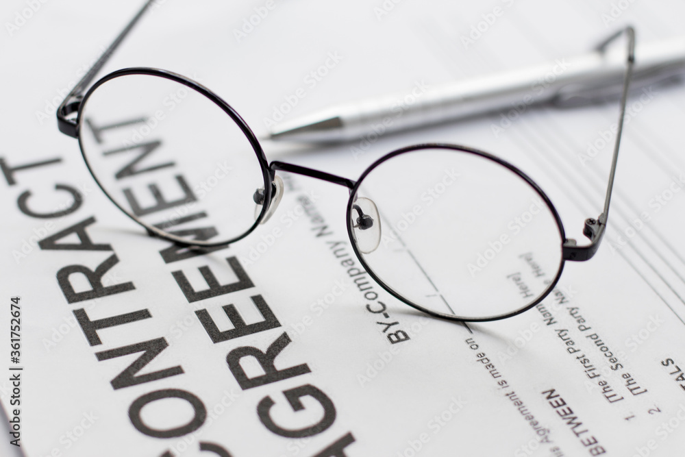 Signing contract with glasses nearby Signing contract with glasses nearby