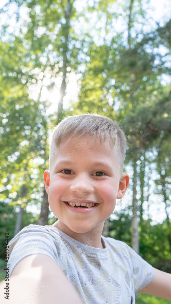 Authentic Funny small boy taking selfies and laughing. Smiling cute boy taking photos and facetime chatting with family. Vertical photo. Authentic Funny small boy taking selfies and laughing. Smiling cute boy taking photos and facetime chatting with family. Vertical photo.