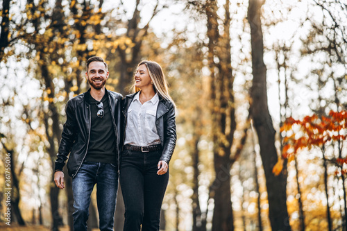 Beautiful young couple walking in the autumn park on a sunny day © bedya