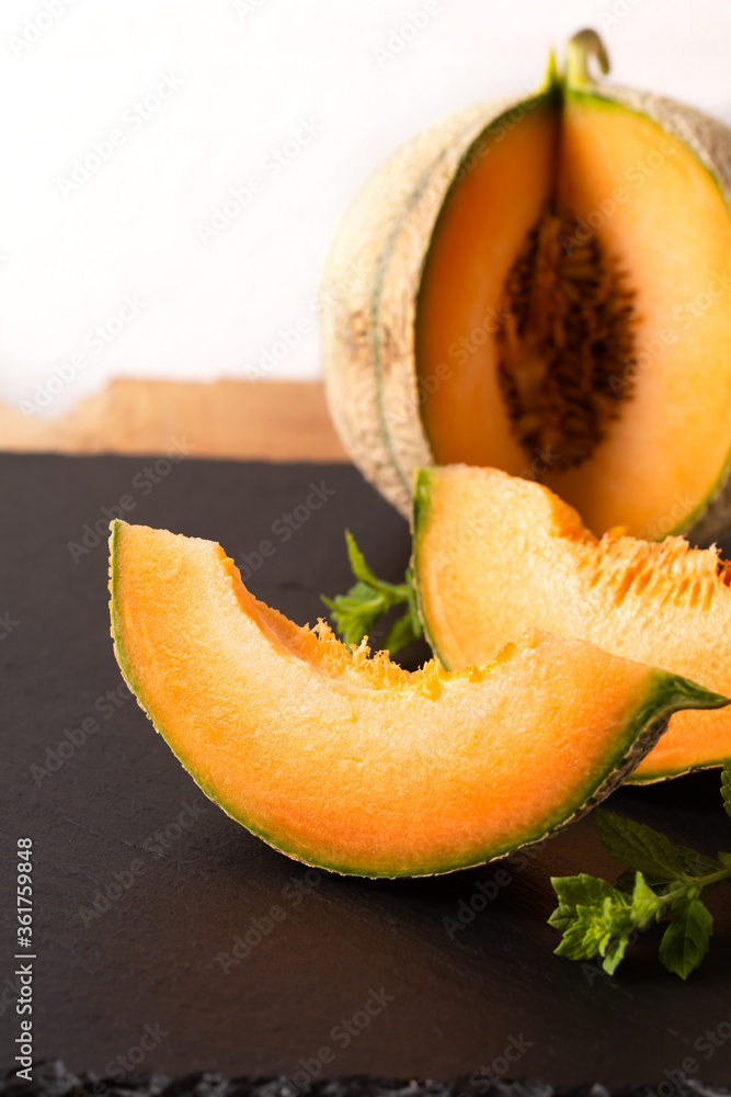 Summer food concept Melon fruit on black slate board with copy space Summer food concept Melon fruit on black slate board with copy space