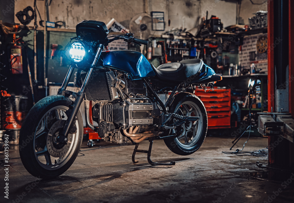 Custom bobber motorcycle with front light on in workshop or garage