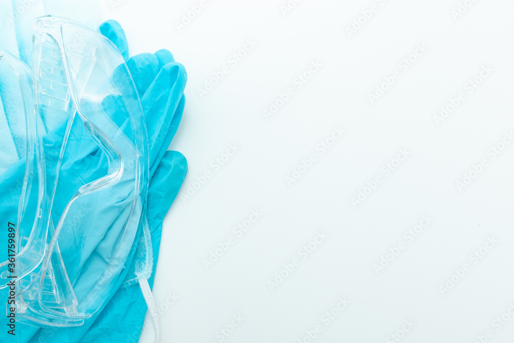 Fototapeta premium individual protection means medical masks and gloves on light background, medical supplies and free space for text