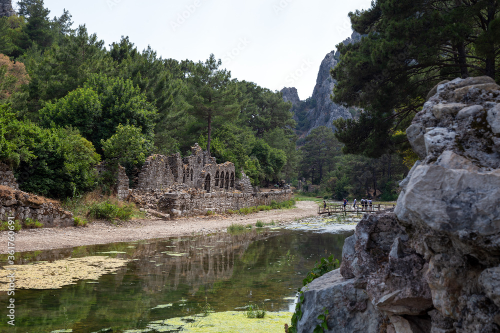 Ruins of the ancient city of Olympos in Cirali village in Antalya, Turkey. Local and foreign tourists come to visit the ancient city and swim. Ruins of the ancient city of Olympos in Cirali village in Antalya, Turkey. Local and foreign tourists come to visit the ancient city and swim.