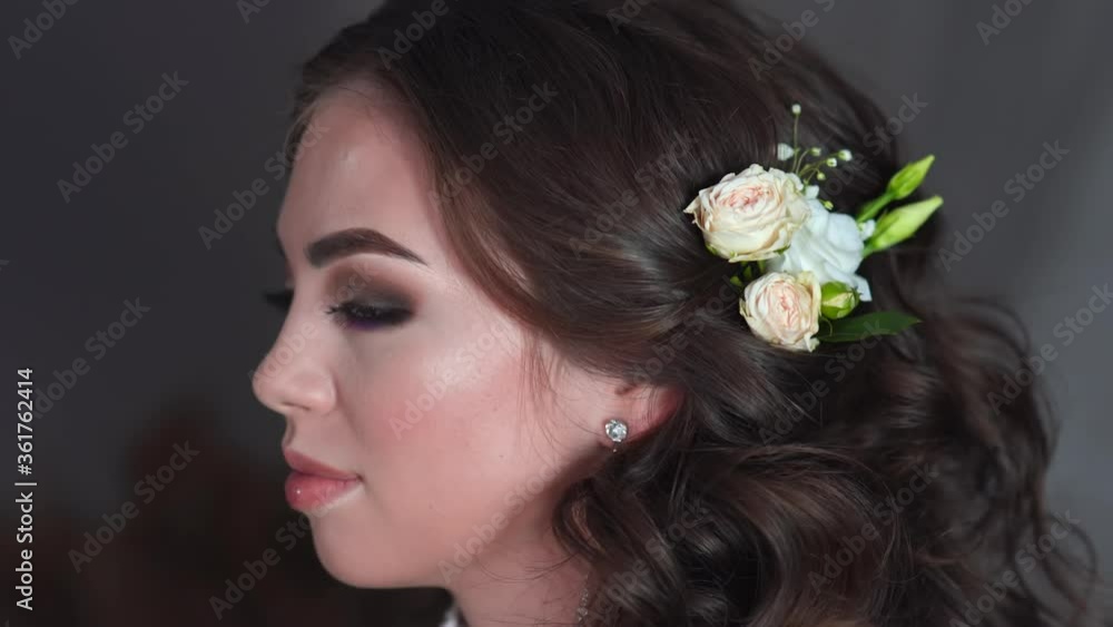 The stylist adorns the girl's hair with delicate flowers. The stylist adorns the girl's hair with delicate flowers.