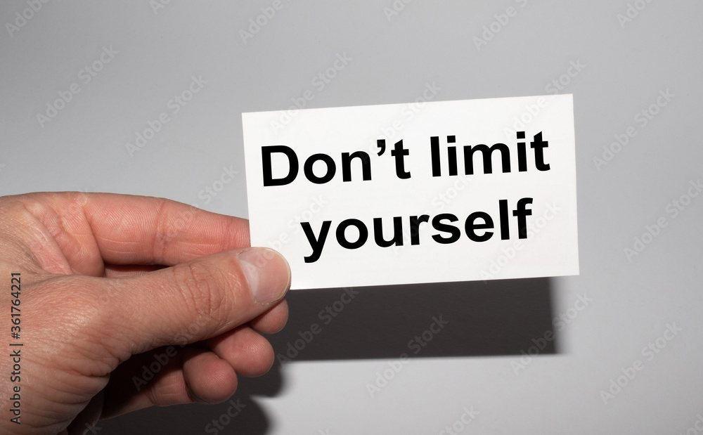 Message on the card DON'T LIMIT YOURSELF, in hands of businessman. Message on the card DON'T LIMIT YOURSELF, in hands of businessman.