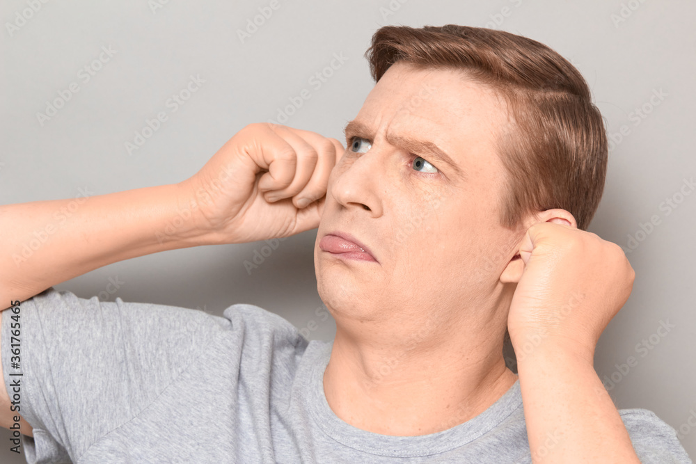 Portrait of funny mature man touching his ears and showing tongue Portrait of funny mature man touching his ears and showing tongue