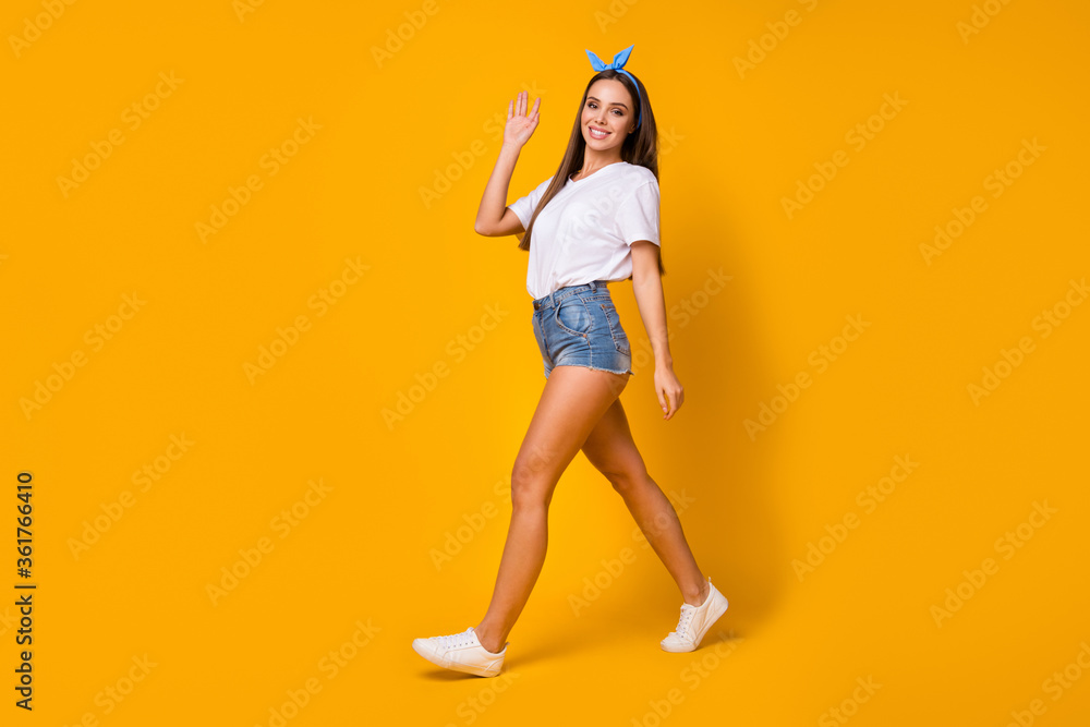 Full size photo of charming candid lovely sweet girl go walk rest relax see look her fellow hold hand greet wear legs white jeans t-shirt footwear isolated bright color background Full size photo of charming candid lovely sweet girl go walk rest relax see look her fellow hold hand greet wear legs white jeans t-shirt footwear isolated bright color background