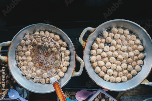 Cooking meatballs in the boiling oil in frying pan photo