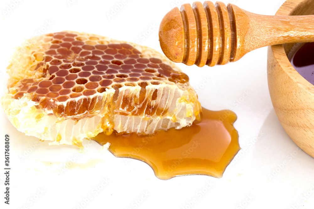 Honeycomb with honey dipper isolated on white background Honeycomb with honey dipper isolated on white background