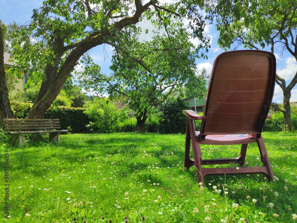 Empty chair in the garden waiting for someone to relax in it on a lovely day in Franconia, Germany Empty chair in the garden waiting for someone to relax in it on a lovely day in Franconia, Germany
