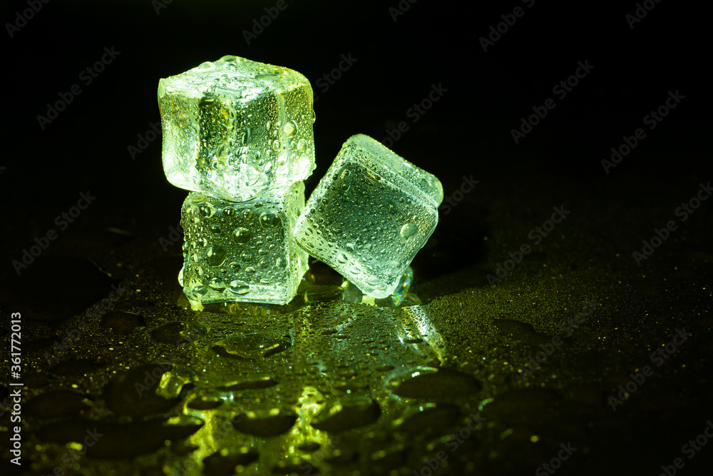 Green ice cubes on black table background. Green ice cubes on black table background.