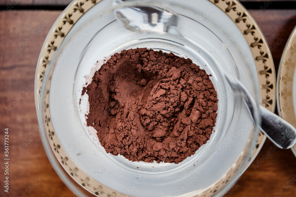 Overhead view of cinnamon powder, cocoa powder and cream in bowls on wooden table Overhead view of cinnamon powder, cocoa powder and cream in bowls on wooden table
