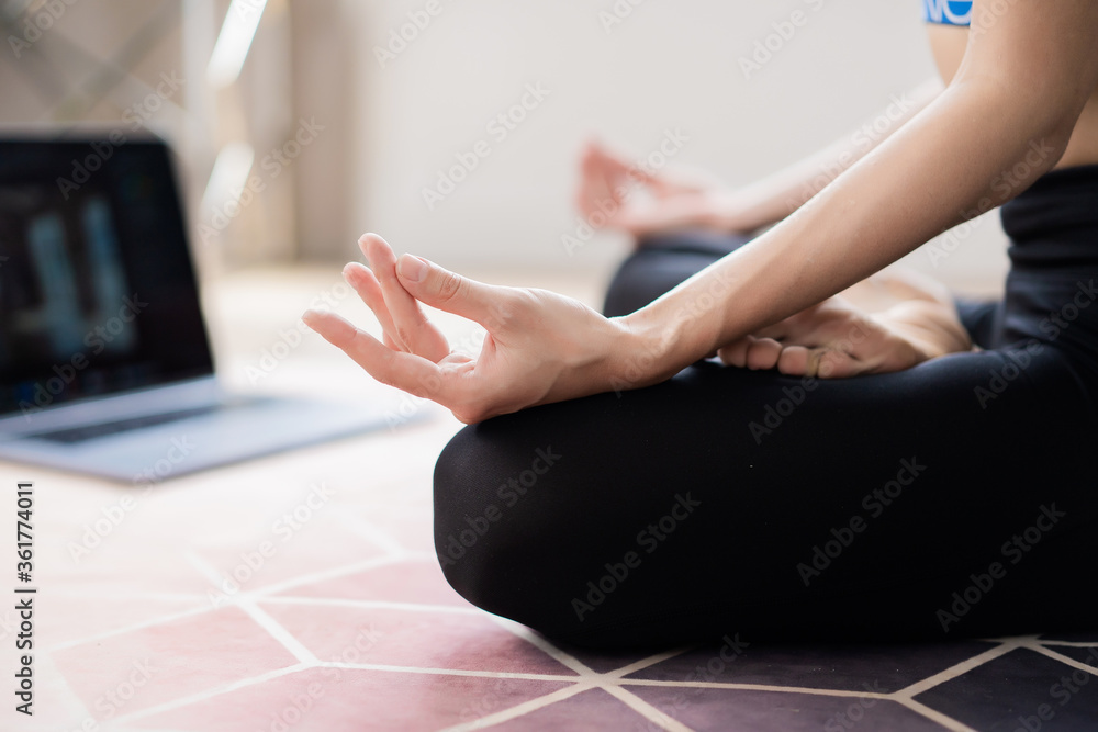 female hands folded for meditation and on laptop background
