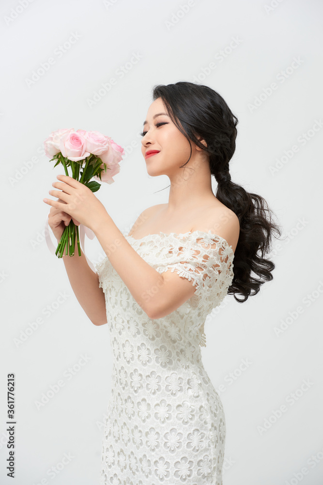 Young attractive Asian model like a bride with bridal bouquet at studio looking Young attractive Asian model like a bride with bridal bouquet at studio looking