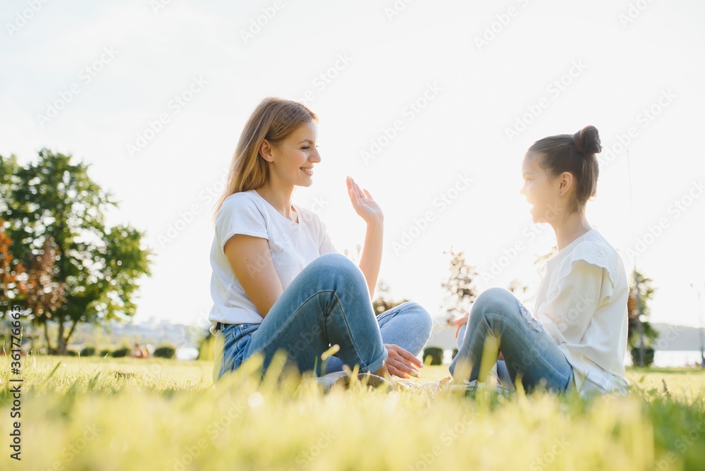 Mother and daughter having fun in the park. Happy family concept. Beauty nature scene with family outdoor lifestyle. Happy family resting together. Happiness and harmony in family life. Mother and daughter having fun in the park. Happy family concept. Beauty nature scene with family outdoor lifestyle. Happy family resting together. Happiness and harmony in family life.