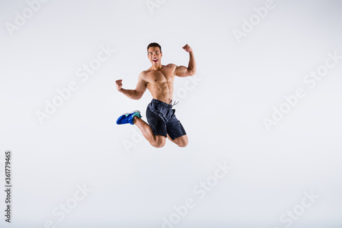 Full length body size view of his he nice attractive sportive cheerful cheery guy jumping having fun rejoicing cup winning isolated over light white pastel color background