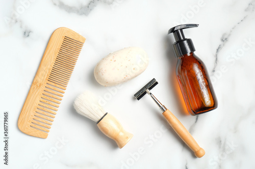 Fototapeta Naklejka Na Ścianę i Meble -  Flat lay composition with bath accessories and shaving tools for man on marble background. Top view wooden hair comb, handmade soap, shaving brush, razor, shampoo bottle.