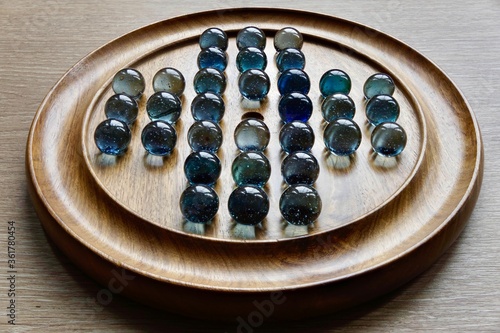 фотографія vintage solitaire game with marbles on a wooden board