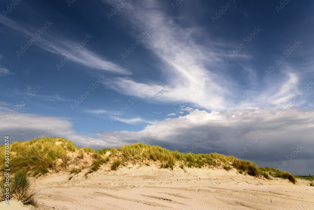 Dramatischer Wolkenhimmel über einer Dünenlandschaft