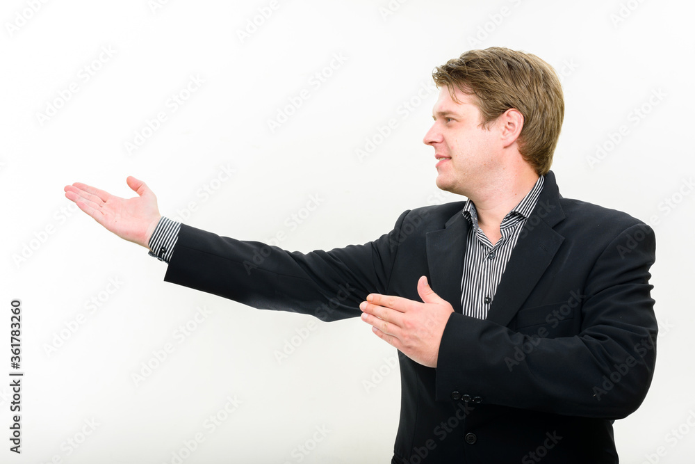 Portrait of happy young handsome businessman showing something Portrait of happy young handsome businessman showing something