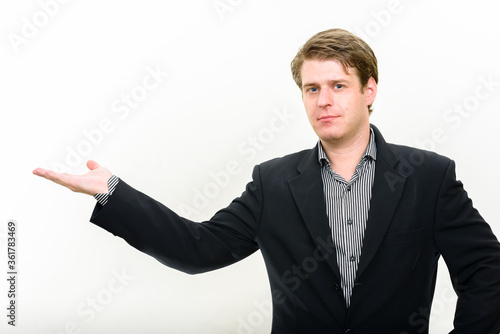 Portrait of young handsome businessman showing something