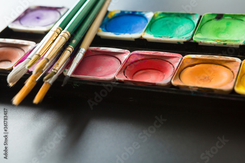 Colorful of Watercolor palette and paintbrush on a black background