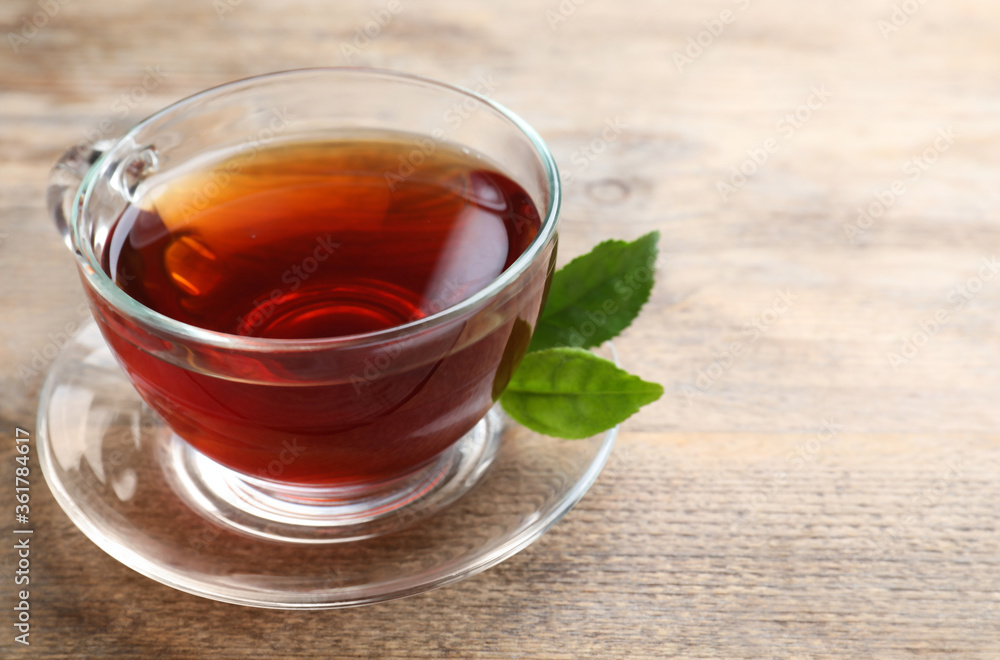 Cup of tasty black tea on wooden table. Space for text Cup of tasty black tea on wooden table. Space for text