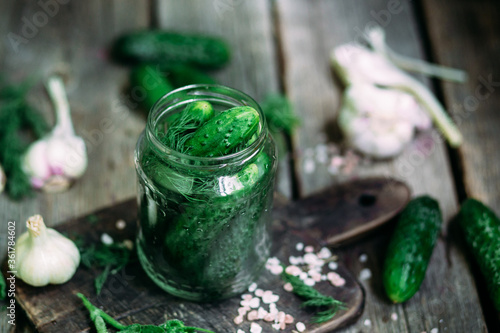 Recipe for pickling cucumbers. Jar with cucumbers on a wooden table