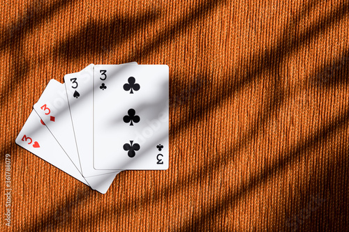 Four of a kind playing cards three, poker card in orange background.