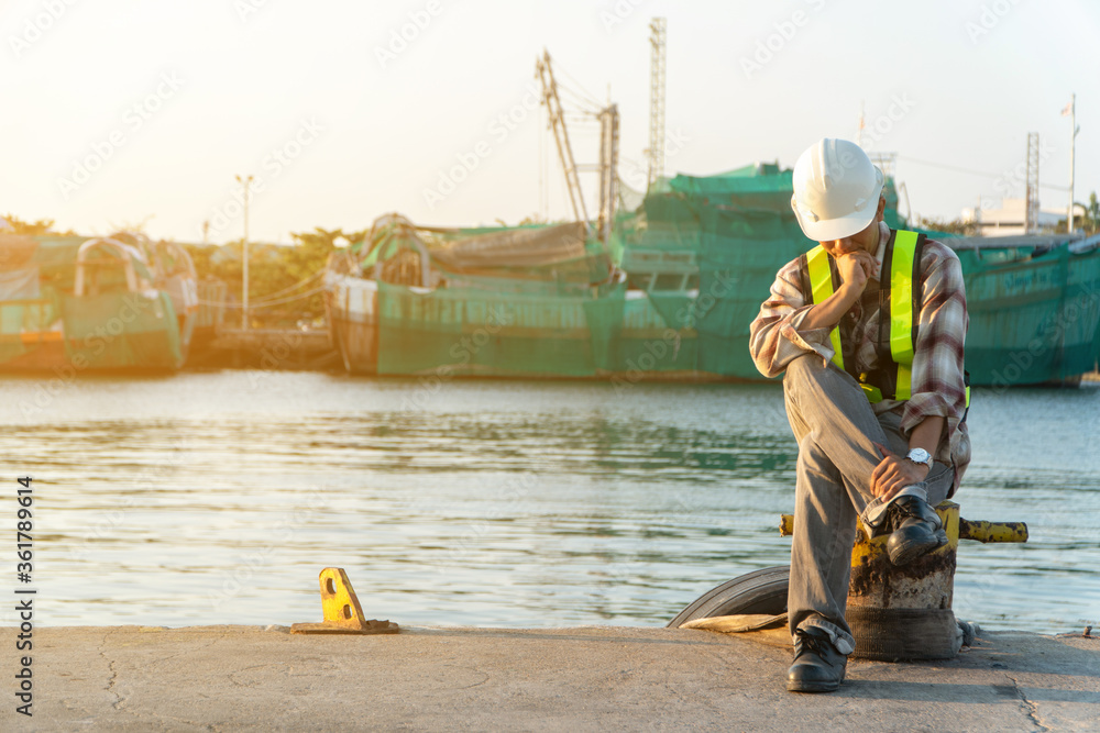 Engineers wearing a safety helmet and sitting and thinking. Concept of The concept of determination and determination in the work and achieving success Engineers wearing a safety helmet and sitting and thinking. Concept of The concept of determination and determination in the work and achieving success