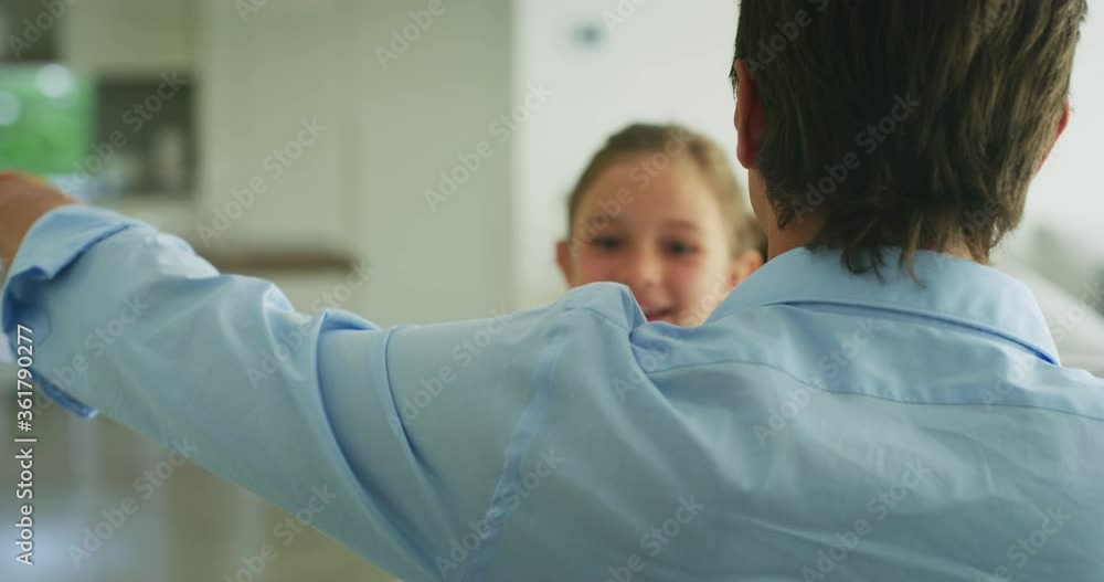 Authentic shot of an young happy smiling father is enjoying time together with his cute little girl in the kitchen. A daughter is giving a hug to a father, they are happy to spend time together. Authentic shot of an young happy smiling father is enjoying time together with his cute little girl in the kitchen. A daughter is giving a hug to a father, they are happy to spend time together.