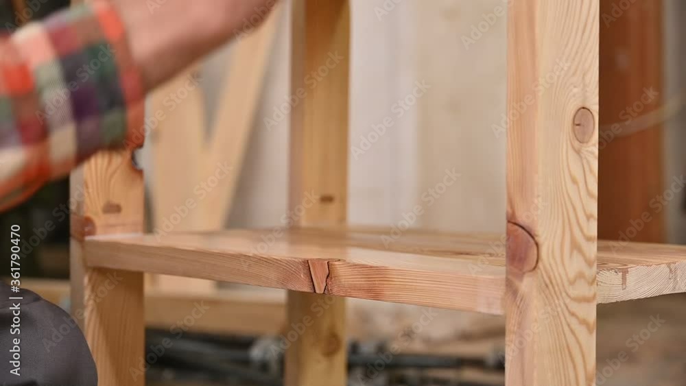 Woodworker puts varnish on a wooden table.Worker is painting wooden details in factory of producing furniture. Hand of man with brush is applying drying oil Woodworker puts varnish on a wooden table.Worker is painting wooden details in factory of producing furniture. Hand of man with brush is applying drying oil
