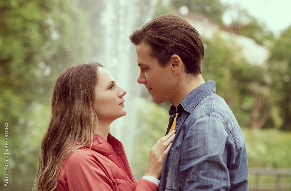 Young, happy, loving couple having date in the park near fountain. Relations, friendship and love. Young, happy, loving couple having date in the park near fountain. Relations, friendship and love.