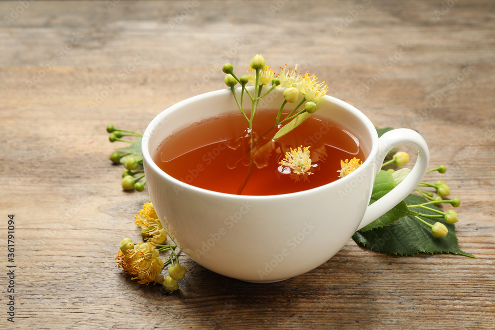 Cup of tea and linden blossom on wooden table Cup of tea and linden blossom on wooden table