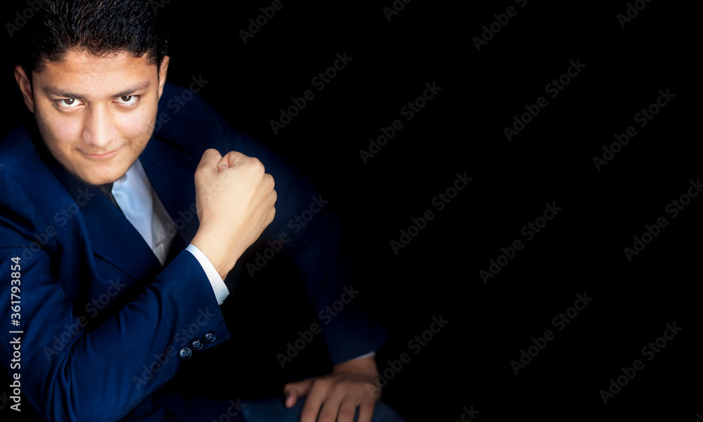 Confident and strong businessman posing over black background ready for any kind of obstacles in life and in businessman.