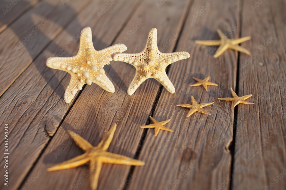 Starfish on a wooden pier poured over a wooden deck. Summer vacation concept. Holidays by the sea Starfish on a wooden pier poured over a wooden deck. Summer vacation concept. Holidays by the sea