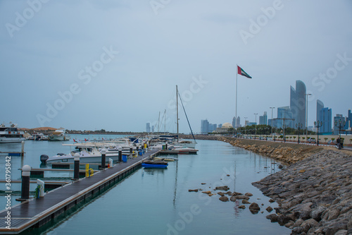 Motorboats & yachts parked at the Abu Dhabi Marina on a rainy day with the Abu Dhabi skyline at the back