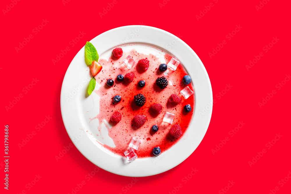 Strawberries and blackberries on defrosted popsicle over a red background Strawberries and blackberries on defrosted popsicle over a red background