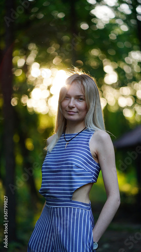 Portrait of a stylish attractive smiling woman in a park