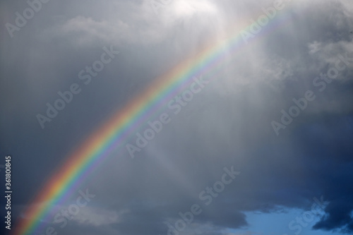 After the storm a rainbow appeared in the sky and the sun's rays broke through the clouds
