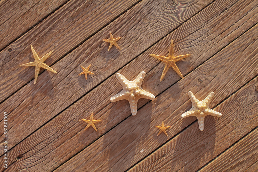 Starfish on a wooden pier poured over a wooden deck. Summer vacation concept. Holidays by the sea